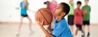 a male boy is shooting a basketball