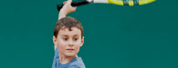 young boy holding tennis racquet