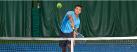 male asian player hitting a tennis ball