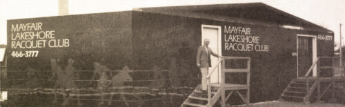 Historical black and white photo of a man standing in front of a temporary structure during the construction of our Mayfair Lakeshore club,