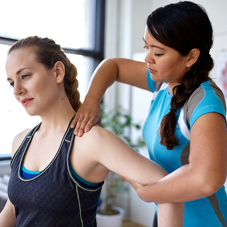 Female Athlete getting her shoulder and neck area tended to by athletic therapist