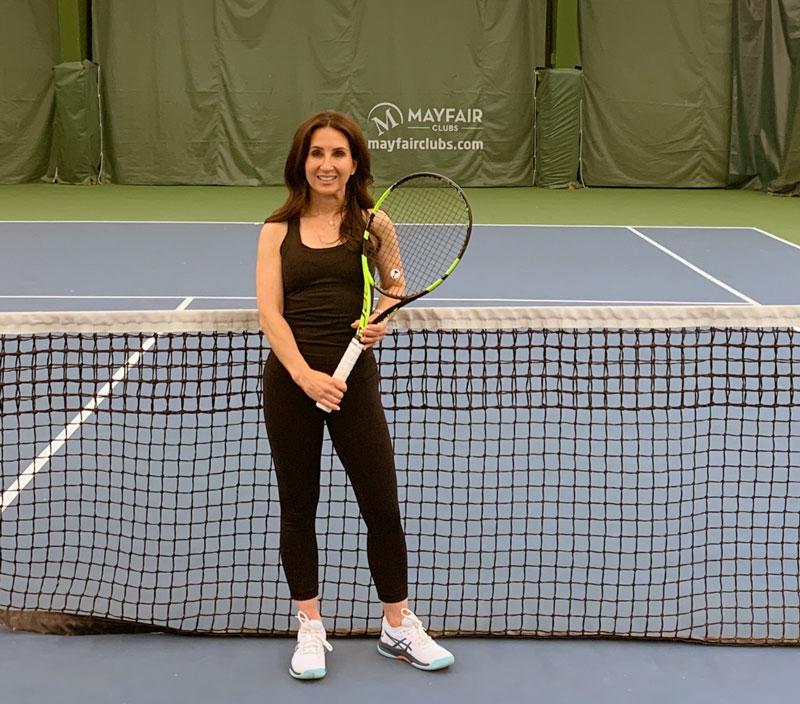 Image of Mayfair West member Gillian Tessis on our Tennis Courts holding a tennis racquet.