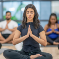 Stock image of yoga class participants in prayer pose.