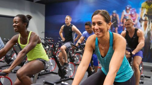 Group of people in an indoor group cycling class