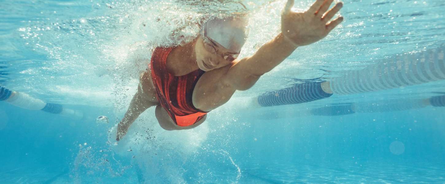 Image of an adult female doing the front crawl in an indoor pool.