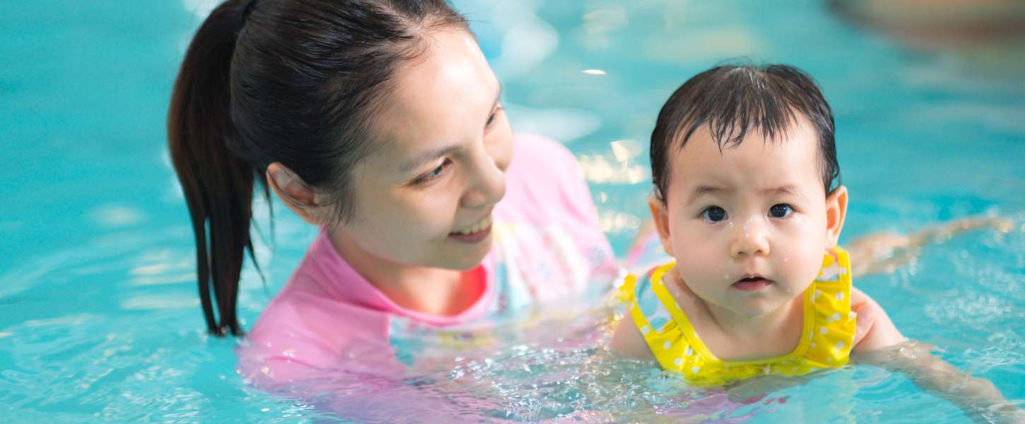Mother and baby in an indoor swimming pool.